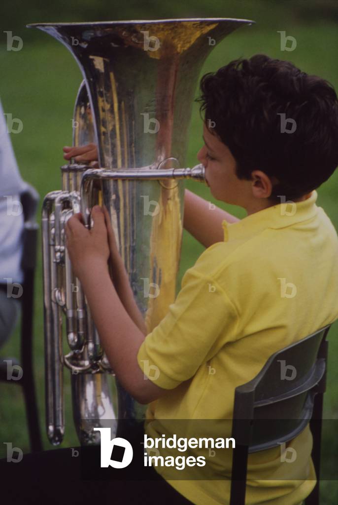 Boy playing tuba in brass band