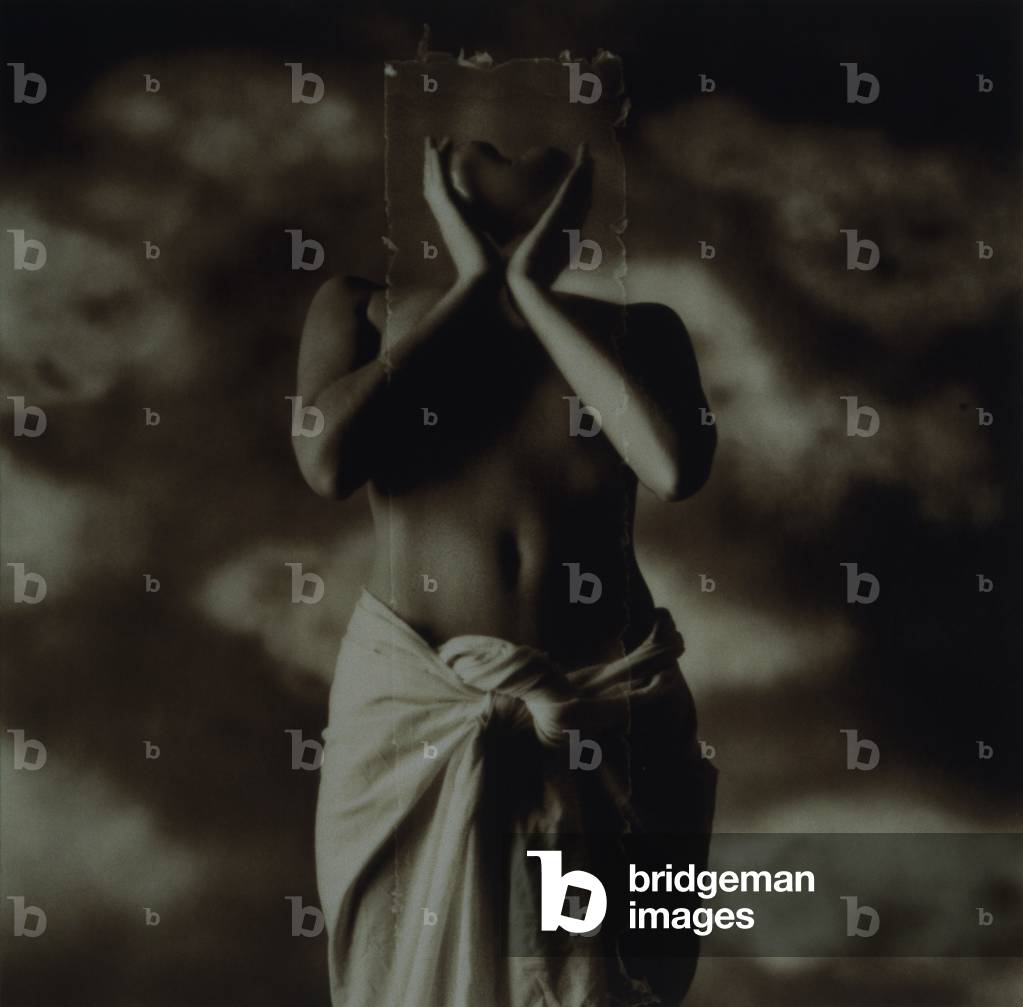 Semi-dress woman holding rectangle with heart shape in front of face