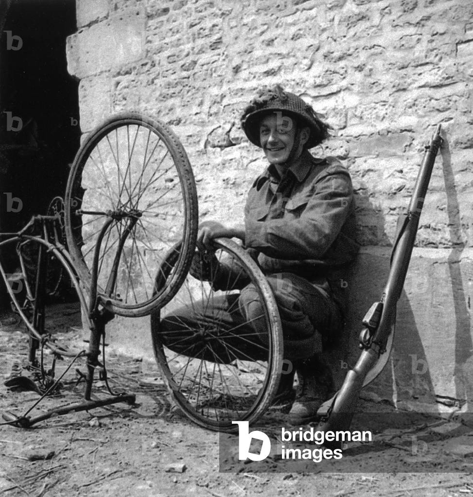 WW2 - Canadian Trooper repairing his bicycle in Normandy
