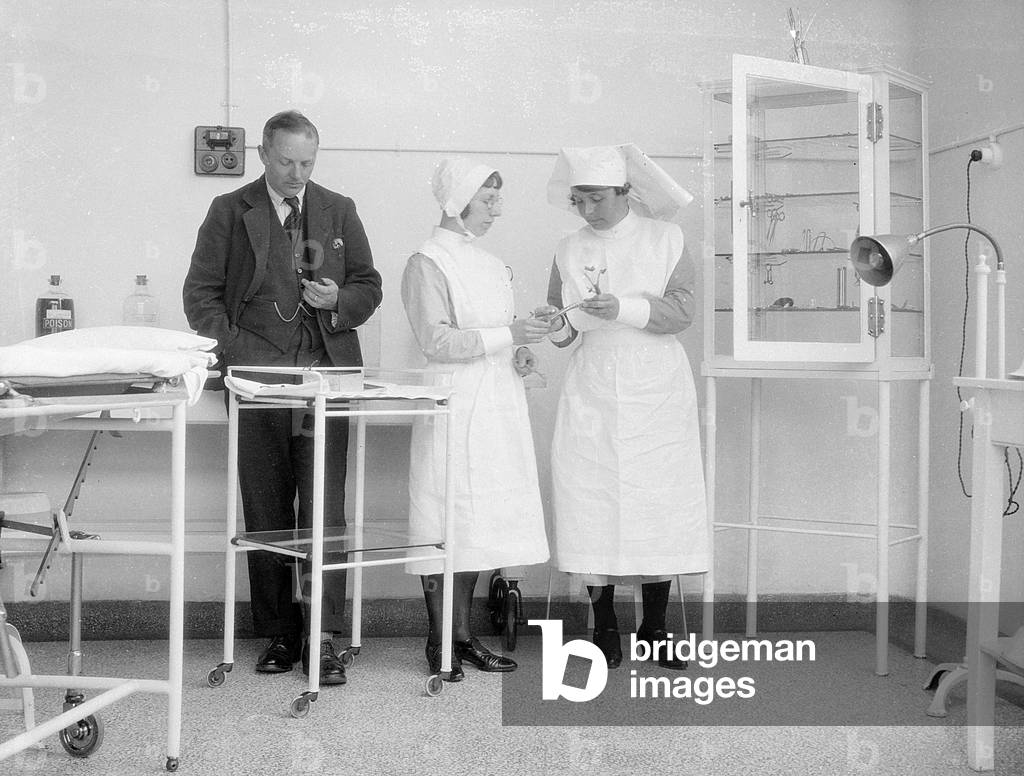 Immagine di Fotografia "MATRONA ISTRUISCE L'INFERMIERA" 1930 di Barnaby's Studios Ltd