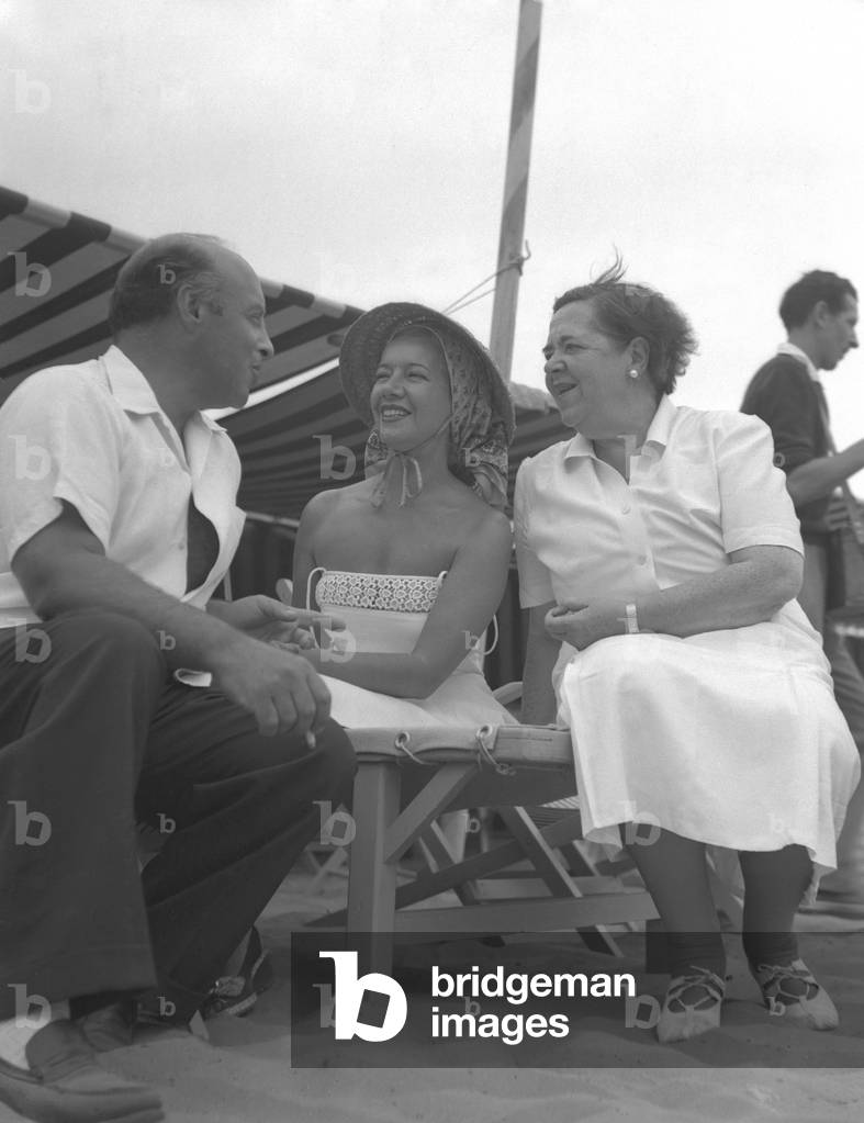 "Americana editorialista di gossip Elsa Maxwell che parla sulla spiaggia con Lily Pons e Andre Kostelanez" 194