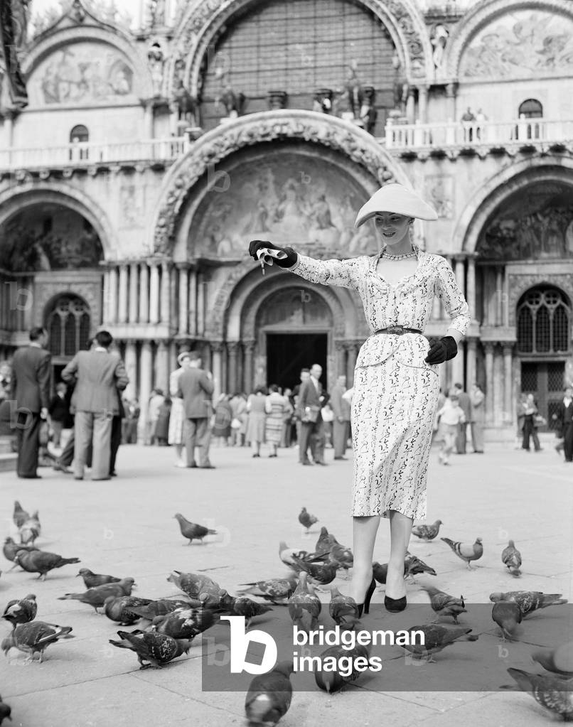 A model wearing Christian Dior fashions feeds the pigeons outside St Mark's Basilica, on the Piazza San Marco in Venice, 3rd June 1951 : Feeding Pigeons