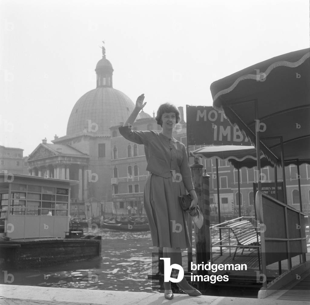 American actress Betsy Blair portrayed while waving outside the railway station, Venice, 1960 : Waitin Fot The Water Taxi