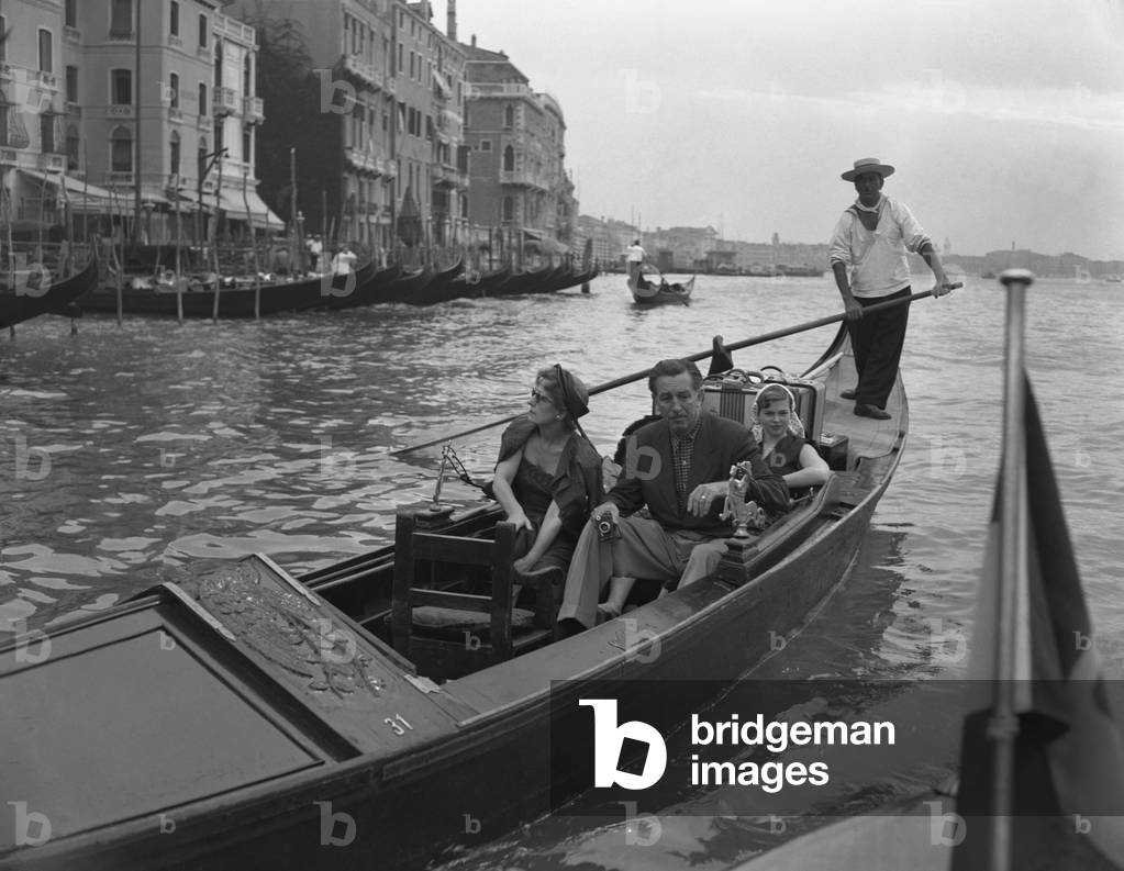 American director Walt Disney, holding a camera, portrayed sitting on a gondola with the family, his wife Lillian and his daughters Diane Marie and Sharon Mae, along the Canal Grande, Venice 1951