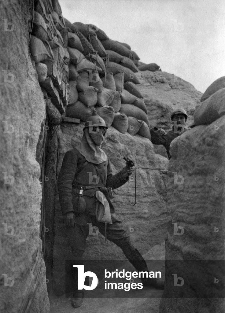 French soldier with a gas hood, a bag for grenades and a German flask, in a trench, France, ww1 (b/w photo)