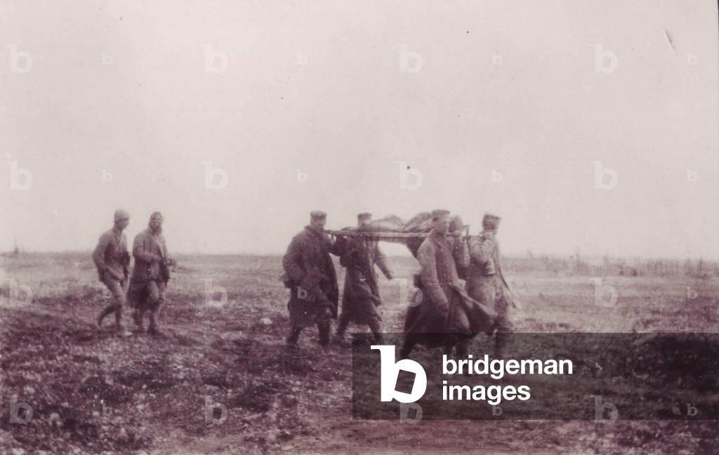 1917-German soldiers prisoners moving away from the battlefield carrying wounded