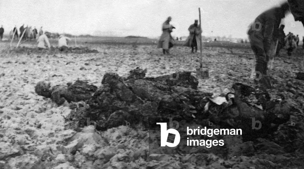 French soldiers digging up bodies from a common grave, 1915 (b/w photo)