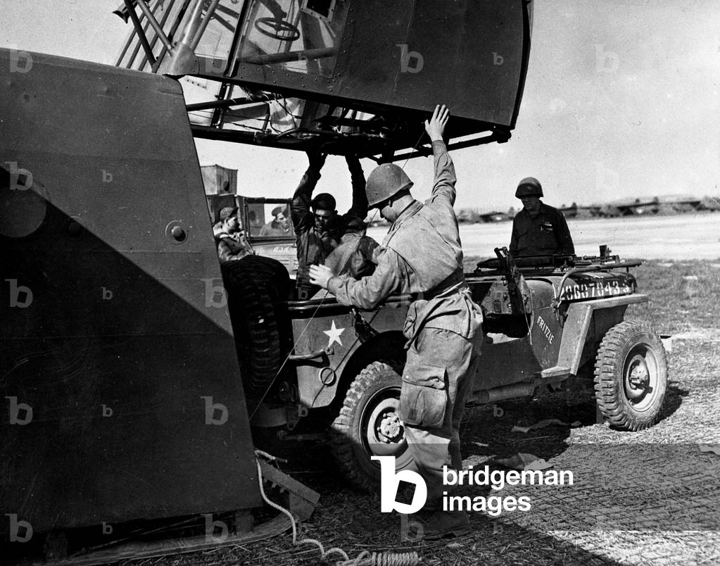 WWII:USAF Base France March 23, 1945: Soldiers of a PIR (Parachute Infantry Regiment) from the 17th American Aeroportee Division of the 1st Armee Aeroportee load a jeep into a Waco CG-4A glider