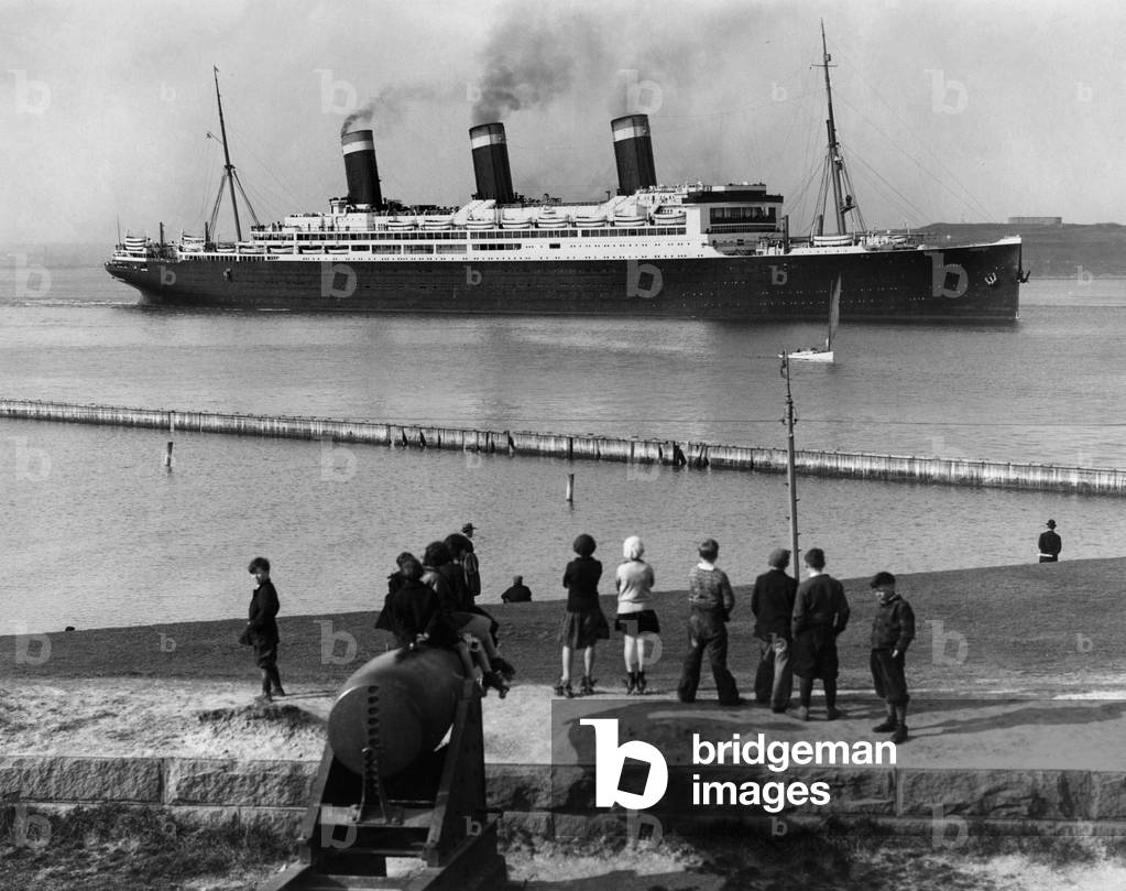 Boston (Massachusetts), USA, circa 1928: The crowd greets the exit of the dry hold of the SS Leviathan (ex-Vaterland) passing the Fort Independence wearing its new colours - Boston, Massachusetts, USA, ca 1928: SS Leviathan (Vaterland) leaving South Boston drydock and passing Fort Independence after her spring cleaning