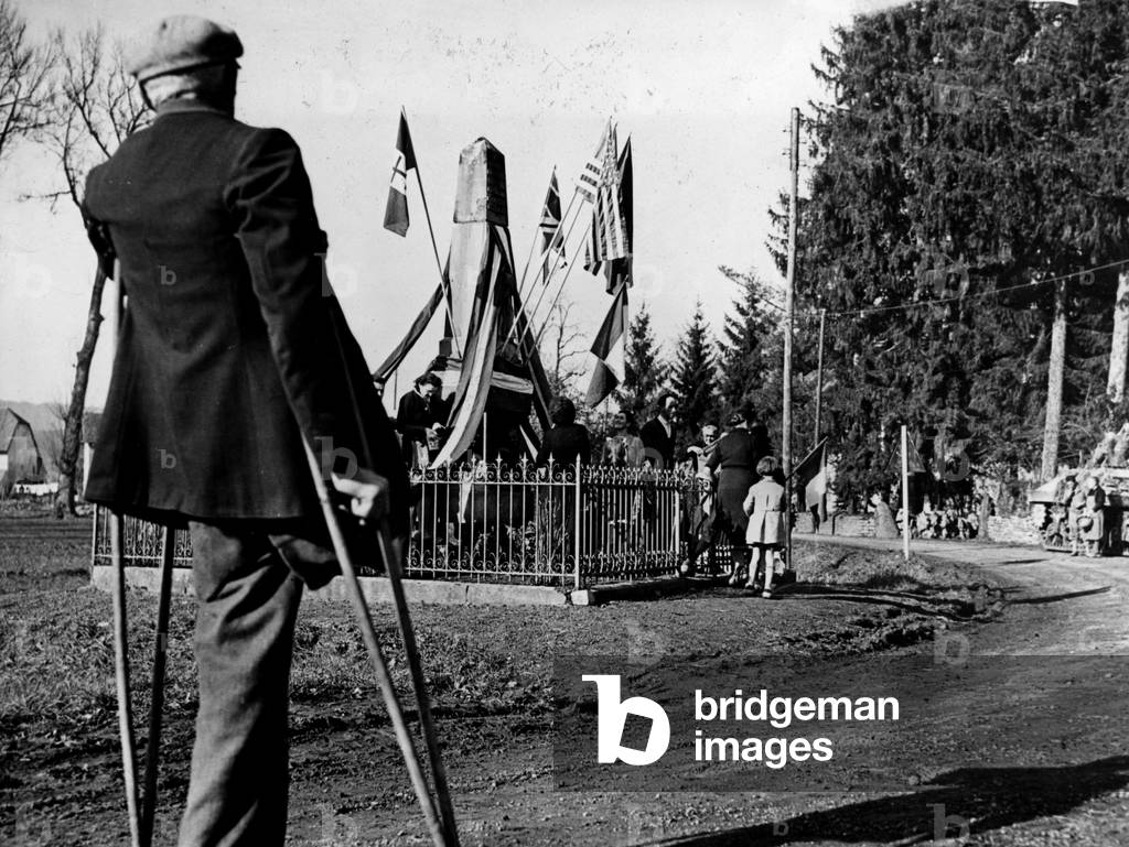 WWII:Couthenans (Upper Saone) at the end of November 1944: Under the eyes of a mutile veteran of the First World War, residents decorate and flourish the Memorial to the Dead of 14-18. The city was liberated on 19 November by blinds of the 1st Armee Fran¿aise