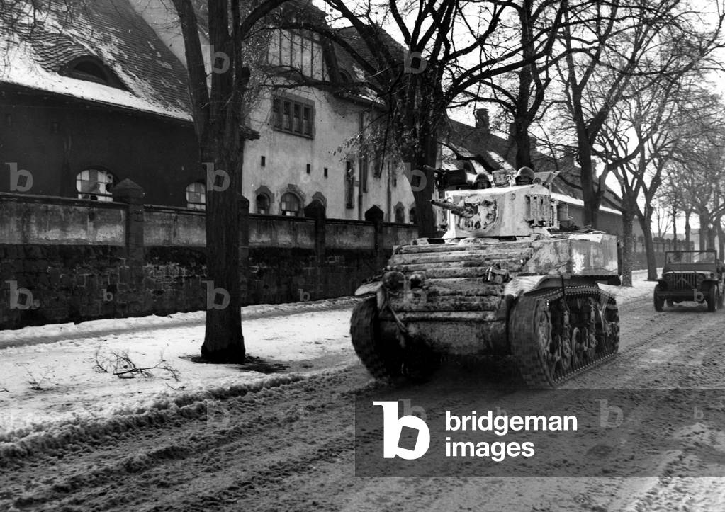 WWII:Colmar (Alsace) France 2 February 1945: A light tank M5 Stuart camouflages the CC4 of the 1st French army in a street of the Alsatian city.