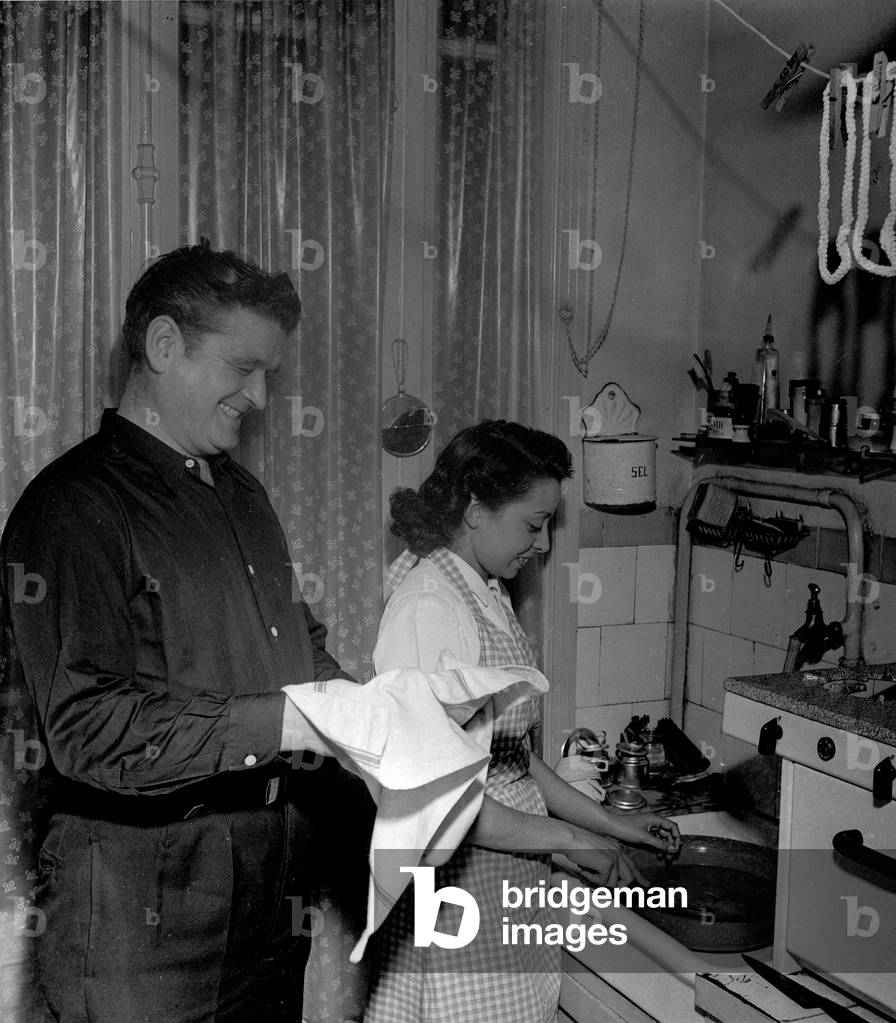 A mechanic from the Gennevilliers electrical plant and his North African wife doing dishes in their apartment in Asnieres (France) in 1949. Photography