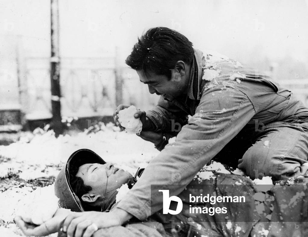 Region of Bruyeres Vosges France beginning November 1944 - two soldiers of the US Army's 442nd RCT (Regiment Combat Team) shake in the snow - This infantry unit is made up of Japanese-American volunteers