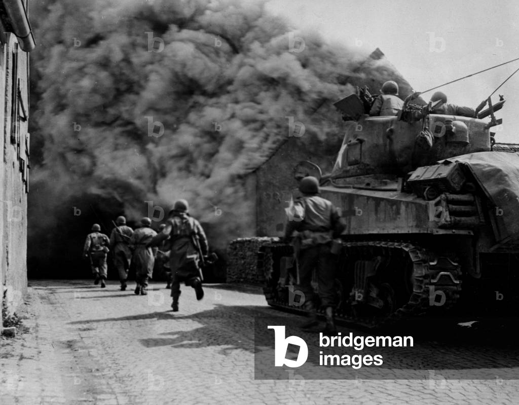 WWII:Wernberg (Germany) April 22, 1945: Soldiers of the 55th Infantry Batallion and a Sherman M4 from the 22nd Tank Batalion of the 11th DB US advance on a smoke street in the city