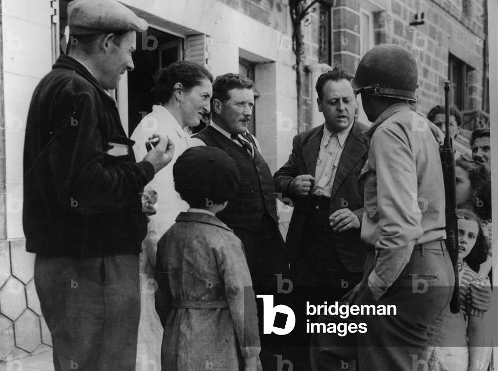 Second World War (1939-1945) - Operation Cobra (July 1944) (WWII - Operation Cobra in Normandy (July 1944): During the offensive west of Saint-Lo (Saint Lo) and shortly after the liberation of the small town of Hambye (Channel), inhabitants chat with an American soldier - Photography beginning August 1944