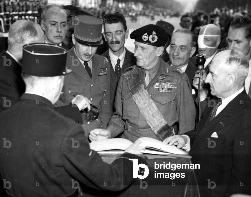 WWII:Paris (France) May 25, 1945: After being decorated by General De Gaulle of the Great Cross of the Legion of Honour, Marechal Sir Bernard Montgomery (CG of the 21st Allied Armees Group) signs the guestbook of the Tomb of the Unknown Soldier under the Arc de Triomery Ph. On his right, the French General Joseph Koenig (Governor of Paris)