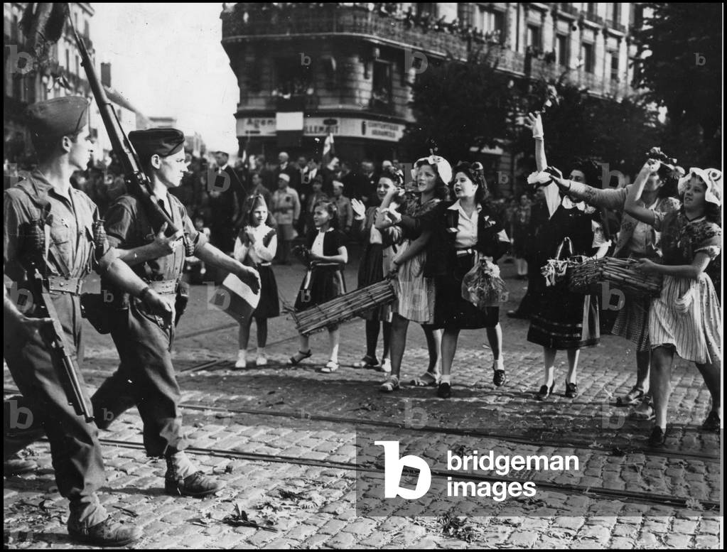 Second World War (1939-1945): young girls and children throw flowers to the soldiers of the 1st French Armee who have just liberated the city of Dijon. Photography September 11, 1944.