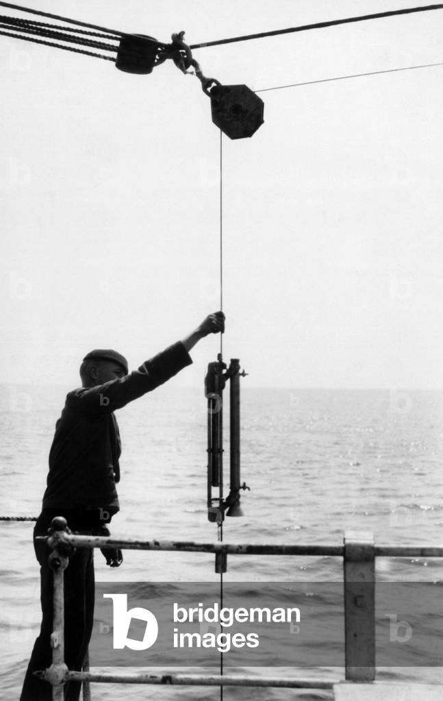 On the USCGC Tampa (WPG-48) on ice patrol, a sailor took a sample of sea water to determine sea currents, ca. 1928 - A sailor on the US Coast Guard Cutter “” Tampa””” obtaining a sample of sea water to determine ocean currents, ca 1928