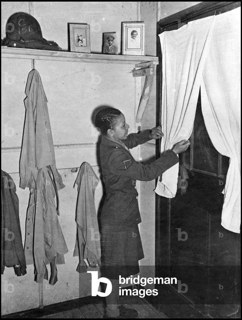 Second World War (1939-1945): an African American Women's Army Corps battalion is in charge of the entire Postal Service of the European Theater of Operations (ETO). A 1st class soldier arranges his curtains at the temporary battalion headquarters. Photograph taken on an American base in Great Britain, February 1945.