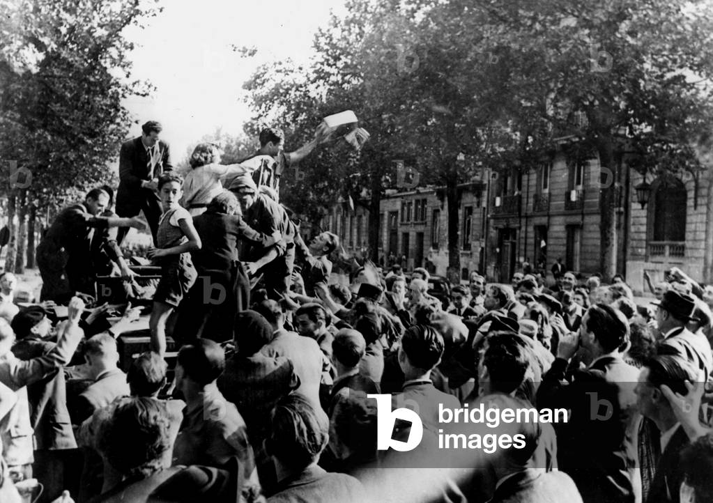 WWII:Parigi (Francia) 25 agosto 1944: L'equipaggio di un carro armato alleato lancia sigarette alla folla pari