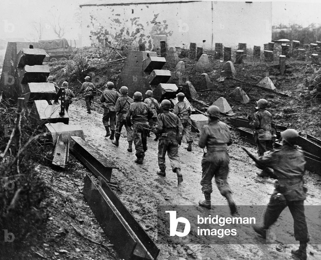WWII:Habscheid (Germany) February 6, 1945: Infantrymen of the 90th US DI “” Tough Shadows”” cross the “Dragon Teeth”” of the Siegfried Line: