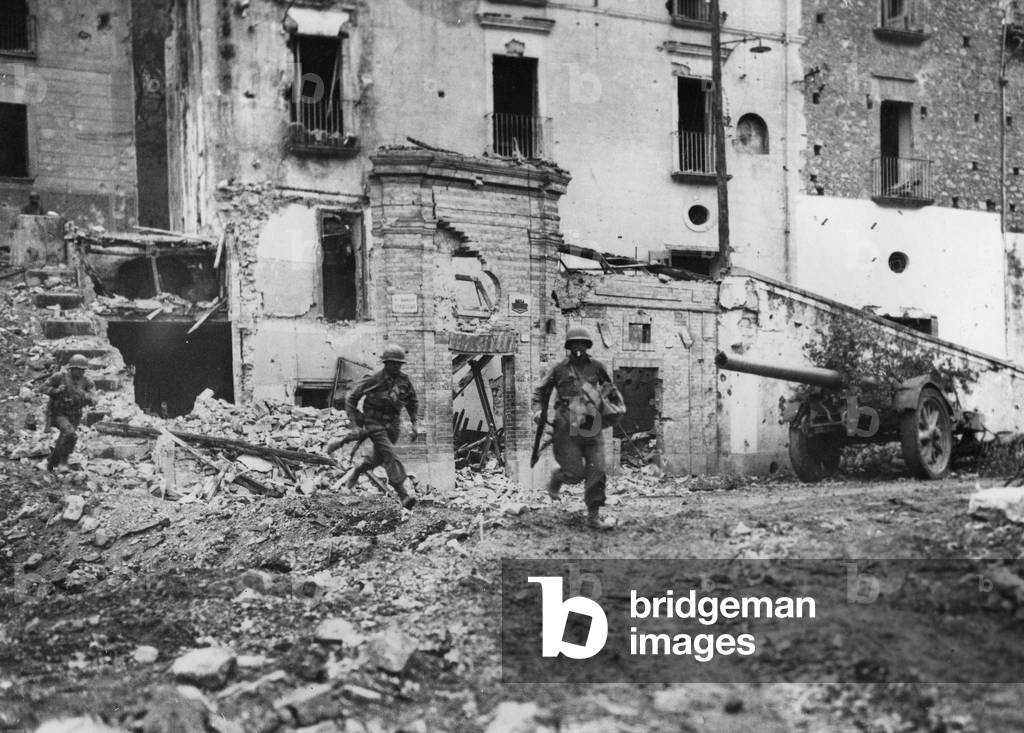 Itri (Italy) around May 19, 1944 - Three infantrymen of the 85th US DI in the ruins of the city. On the right, a German cannon abandons