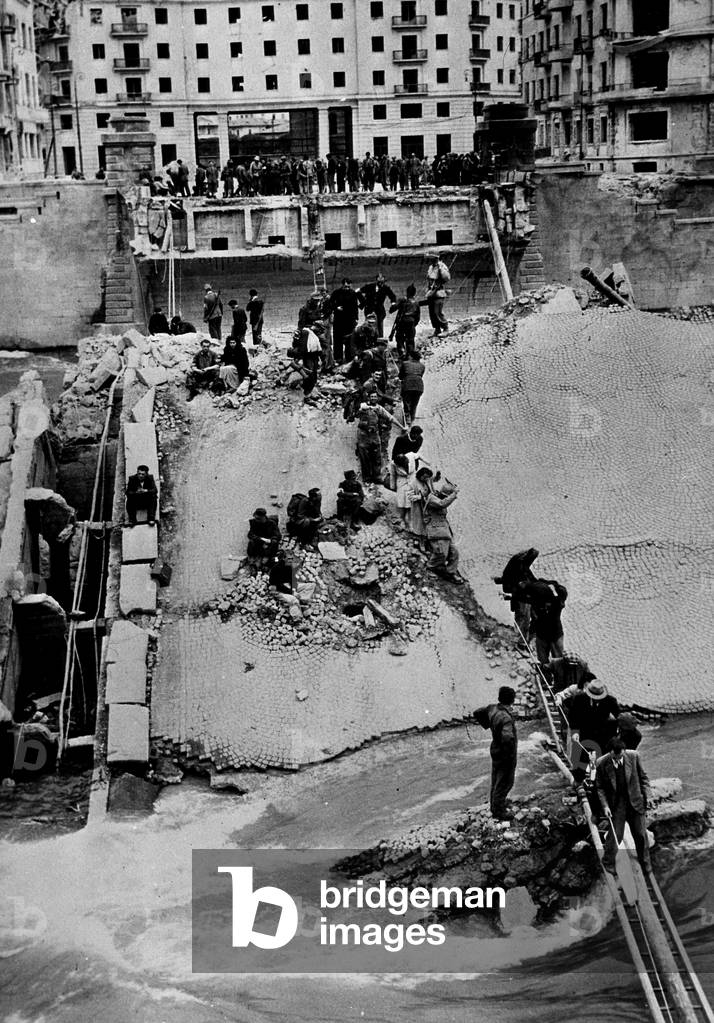 WWII:Verona (Italy) 29 April 1945: Civilians and prisoners cross the detruit bridge of the Victory (Ponte della vittoria) over the Adige. This bridge was dynamited by retired German troops