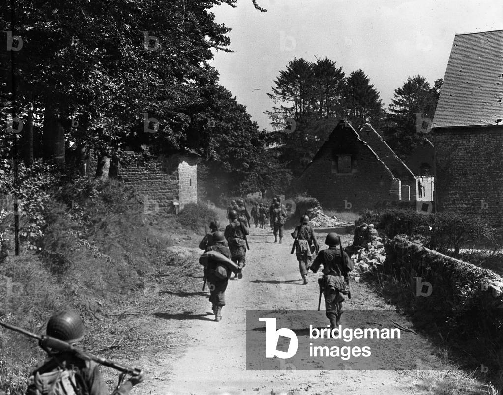 Les Monts d'Eron (Manche) France 14 August 1944 - Infantrymen from the 28th D.I cross the ruined localite