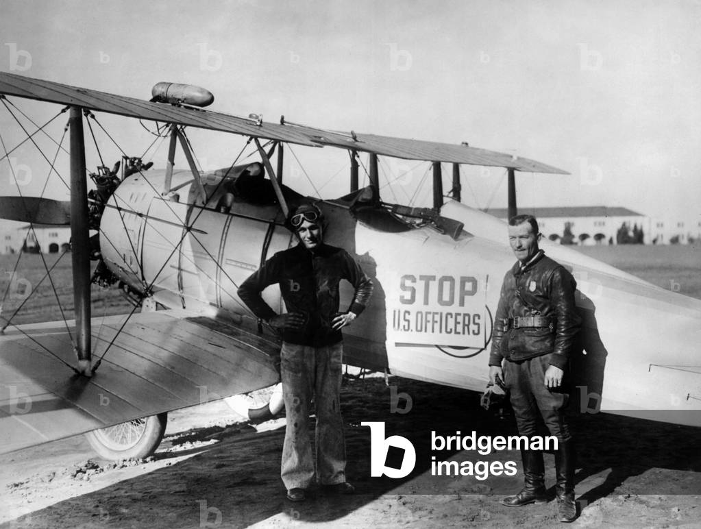 El Paso (Texas), USA, December 1926: Landing in front of one of the planes used by the Border Air Patrol, pilot H.S Springer and Elmer M Sieber (inspector). Border Air Patrol is responsible for controlling immigration at the border between the United States and Mexico - El Paso (Texas), USA, December 1926: plane used by the US border air patrol force and two immigrant officers, HS Springer and Elmer M Sieber