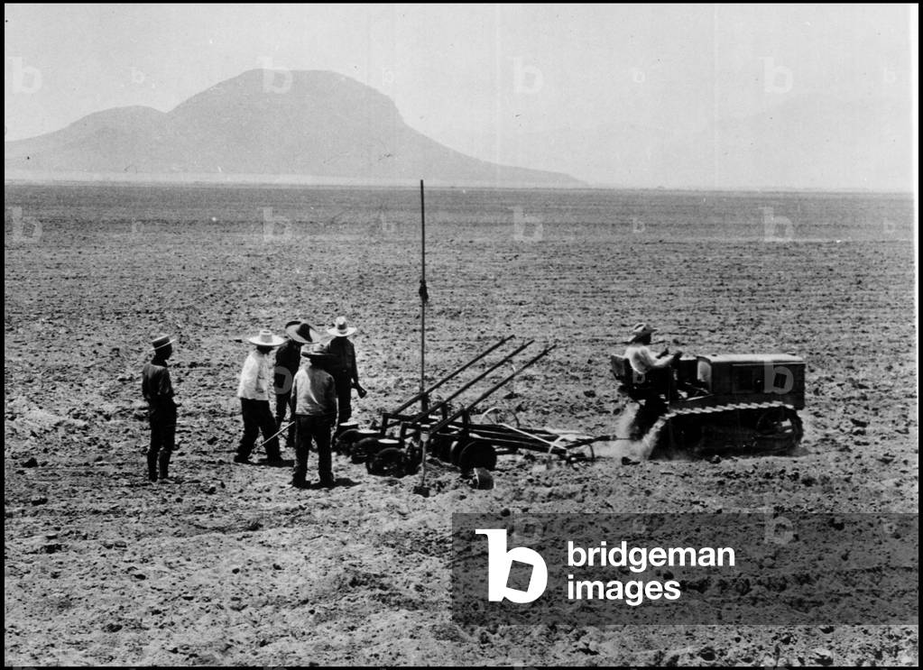State of Pueblo (Mexico) circa 1929: Caterpillar tractor plants manure with some “” peones””