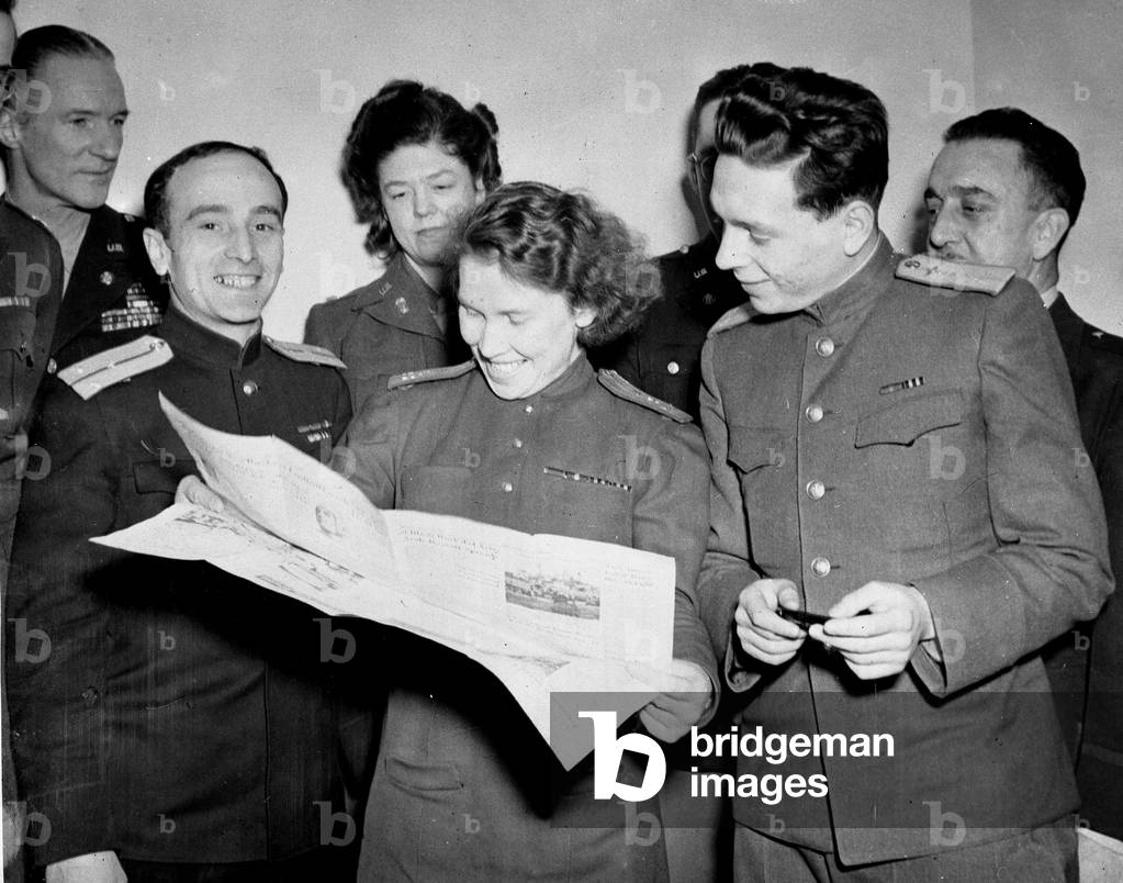 WWII:Frankfurt on the Main American Occupation Zone (Germany) autumn 1945: At the reception gives in their honor to the headquarters of the American forces, three correspondents of sovietic newspapers, from left to right, Lieutenant Alexander Zholkver, Captain Lydia Denisova and Lieutenant Stanislav Levin consult a copy of the newspaper “Stars and Stripes””