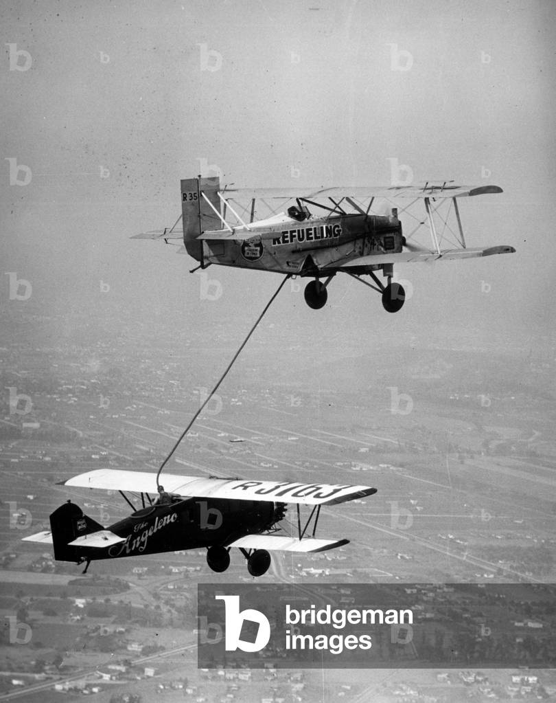 Culver City, California, USA, July 1929: Air refuelling for American pilots Loren W. Mendell and Roland B. Reinhart. They will achieve an endurance record with a flight of 246 hours, 43 minutes aboard their plane “” the Angeleno”” - Culver City, California, USA, July 1929: refueling the Angeleno plane above the city during an endurance flight by Loren W Mendell and Roland B Reinhart