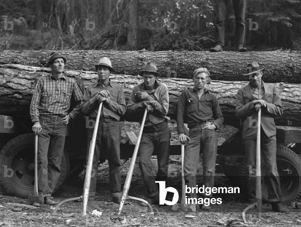 Members of Ola self-help sawmill co-op. Oct. 1939. Five Idaho farmers standing against a load of logs ready to go down to their jointly owned cooperative mill about three miles away