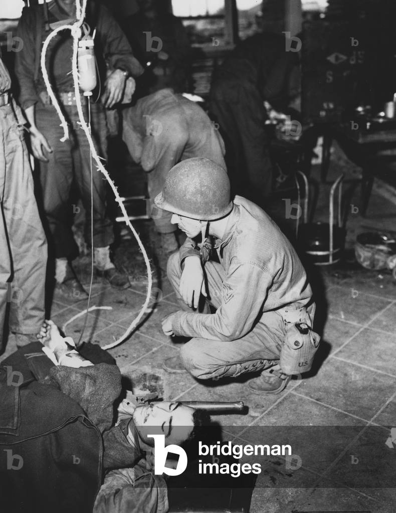 A wounded Marine is given whole blood by a medic, Korea, 1950 (photo)