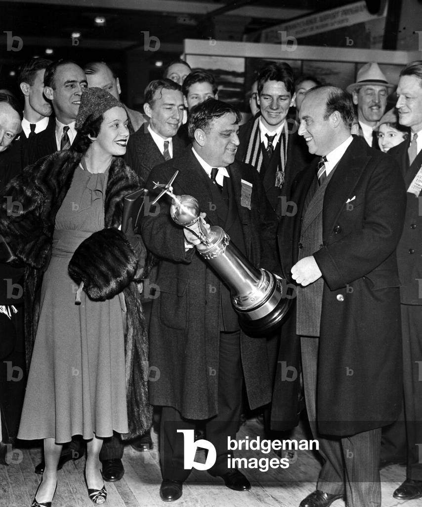 Fiorello LaGuardia, presenting cup to Andre Kostelanetz while opera star Lily Pons looks on, c. 1937