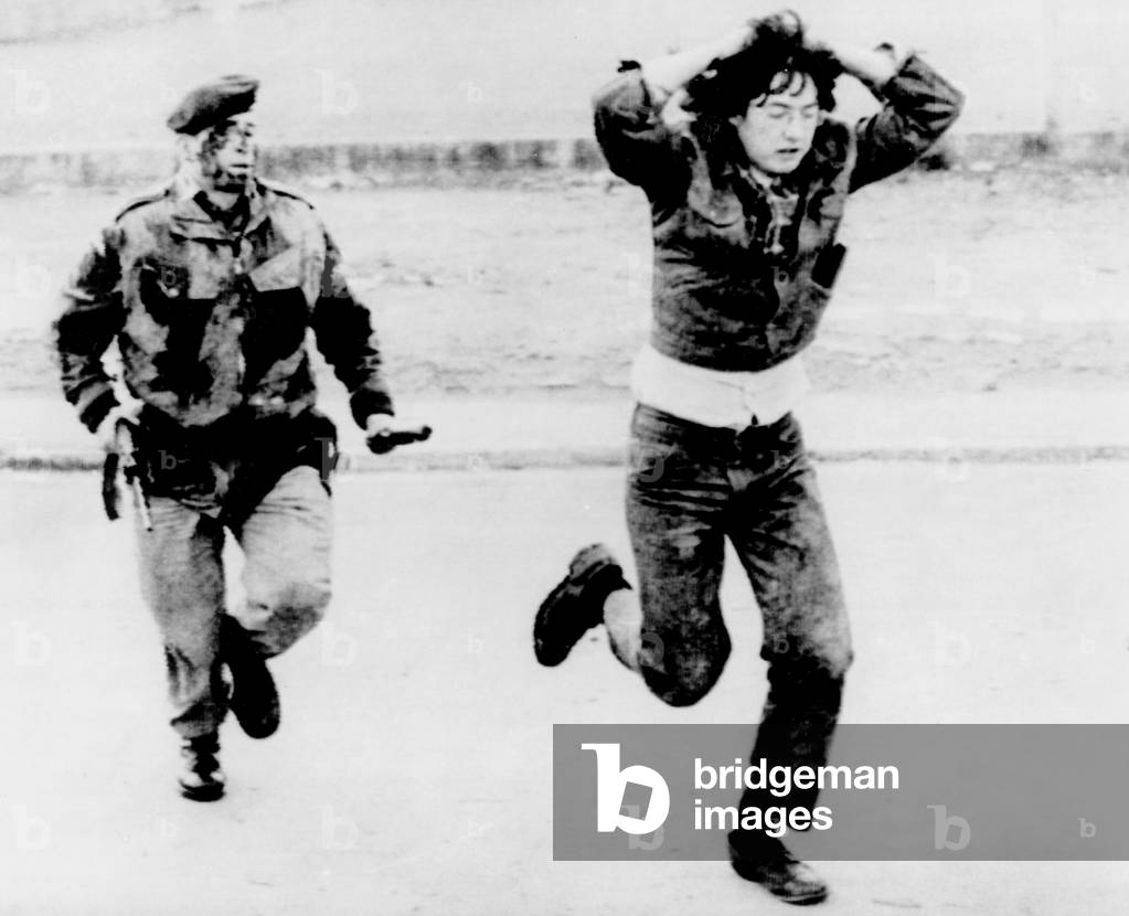 British soldier chasing a demonstrator during a riot in Londonderry, Northern Ireland, 1972
