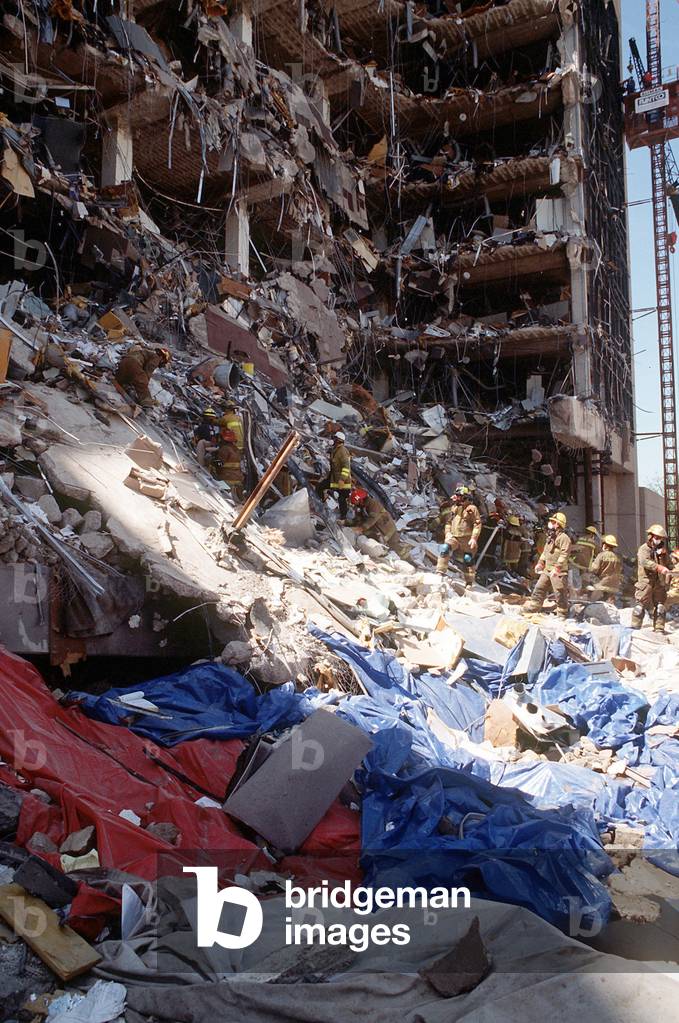Oklahoma City firefighters form a line to remove rubble from the explosion site of the Alfred P. Murrah Federal Building. April 21 1995
