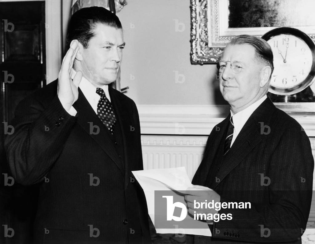 Former Boxer Gene Tunney is commissioned in the Naval Reserves. Tunney takes his oath from Navy Secretary Frank Knox. As a Lt. Commander, Tunney will serve as Physical Director and Coordinator of Physical Education at Naval Air Stations in Pensacola, Corpus Christi, and Jacksonville, Fl. Dec. 20, 1940.