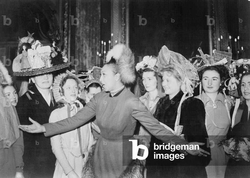 Josephine Baker (1906-1975), surrounded by women wearing elaborate hats, during activities relating to the French Gratitude Train, when gifts and artworks, were sent to the United states in return for US post-war assistance to France. 1948