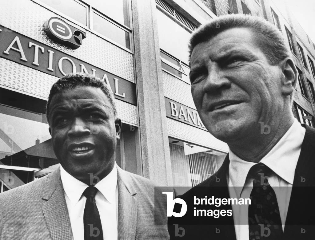 Jackie Robinson, with Robert Preston in front of the Freedom National Bank in Harlem, 1965