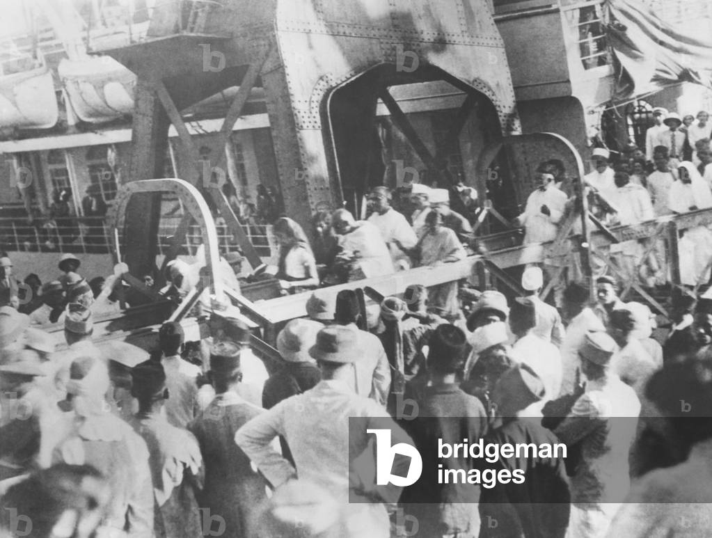 Mahatma Gandhi walking down the gangway arriving at Bombay, India, met by cheering thousands. He was returning from the 2nd London Roundtable Conference that discussed reforms in India. Dec. 1931