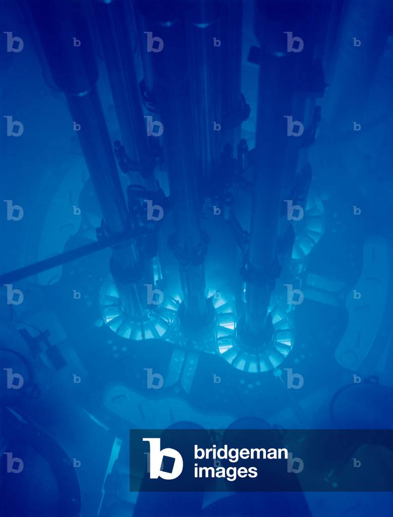 Idaho National Laboratory's Advanced Test Reactor core powered up, with the fuel plates glowing bright blue. The core is submerged in water for cooling, 1990s (photo)