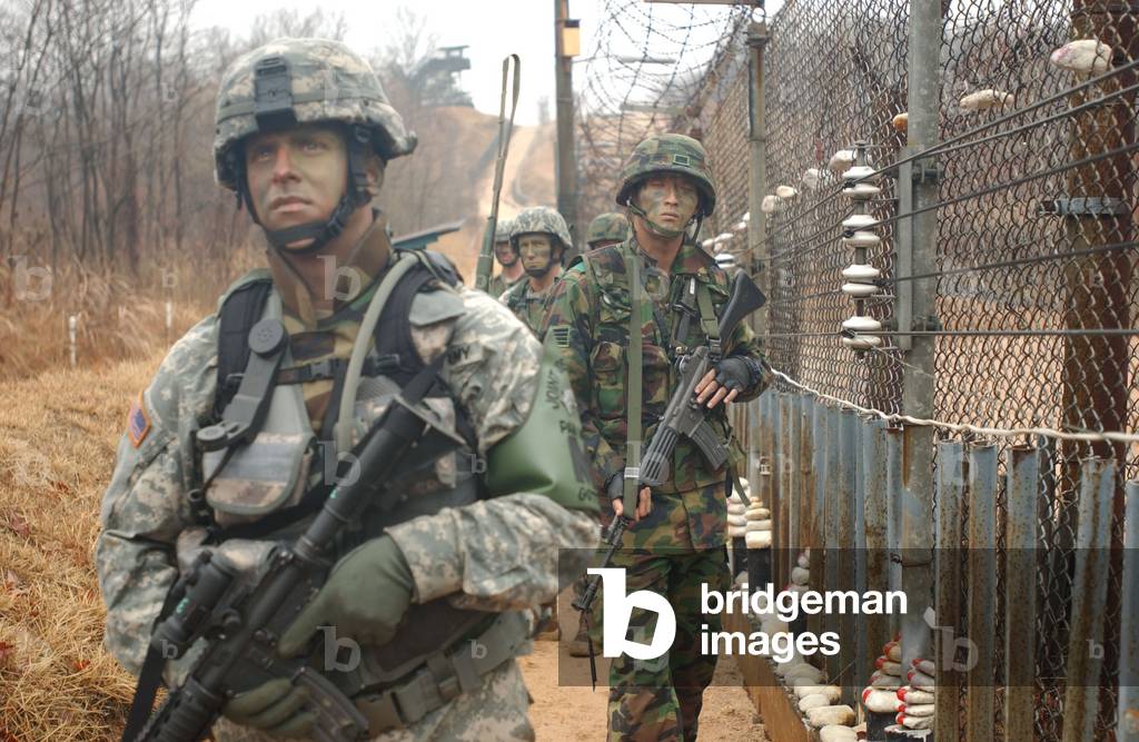 South Korean and US Soldiers patrol long a fence at the United Nations Security Area in Panmunjom during an annual training exercise. March 24 2007