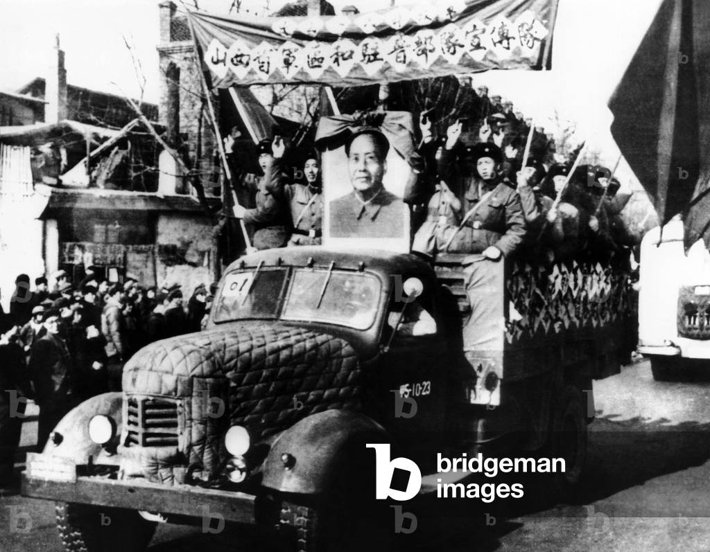 Chinese Cultural Revolution celebration of the defeat within the Shanai Provincial Party Committee of a handful of people who had taken the 'Capitalist Road'. The victorious Red Guards who purged the group ride through the streets with a portrait of Chairman Mao and wave banners and their Little Red Books of Mao sayings. Jan 12, 1967