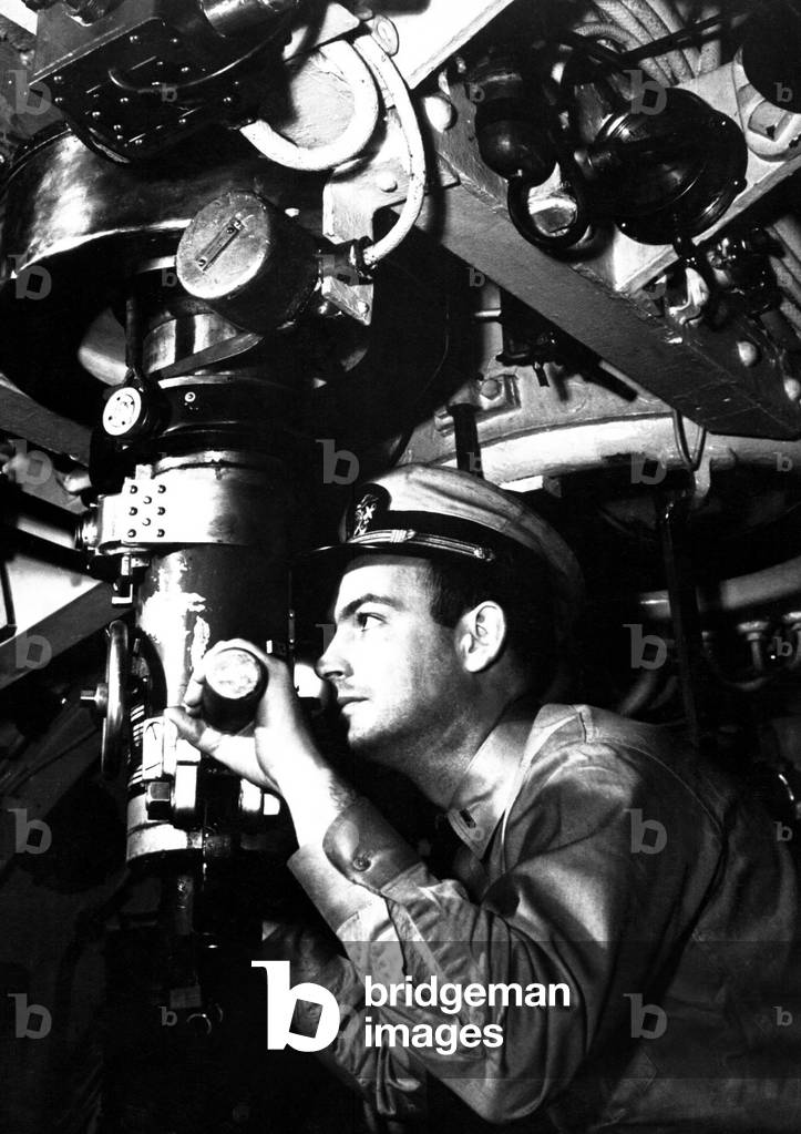 U.S. officer at the periscope of submarine during World War 2. c. 1942