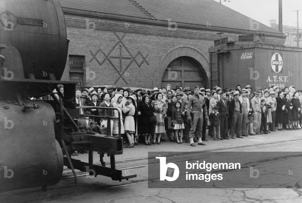Japanese Americans at a train station as the U.S. Military supervises their transport to Owens Valley Assembly center for internment during World War II. Los Angeles, California, April 1942