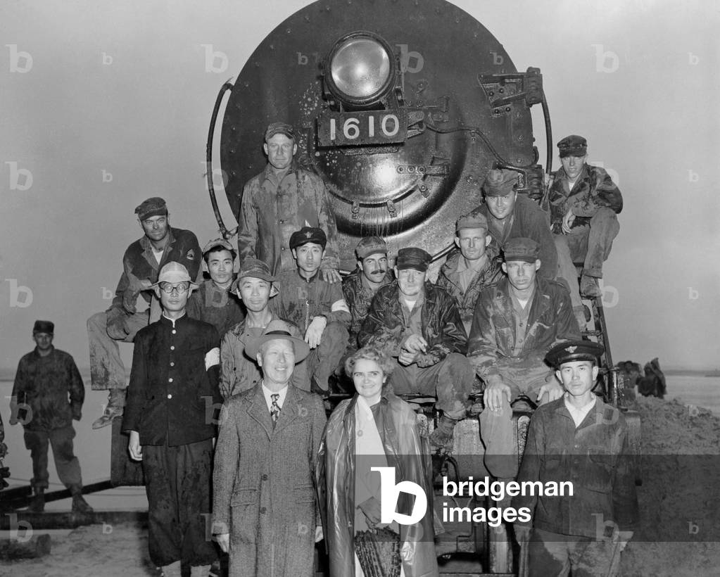 President Syngman Rhee, and Mrs. Rhee with US Army engineers and Korean train crew. They are celebrating the newly constructed railroad bridge spanning the Han River at Seoul, Korea. Oct 19, 1950. Korean War, 1950-53