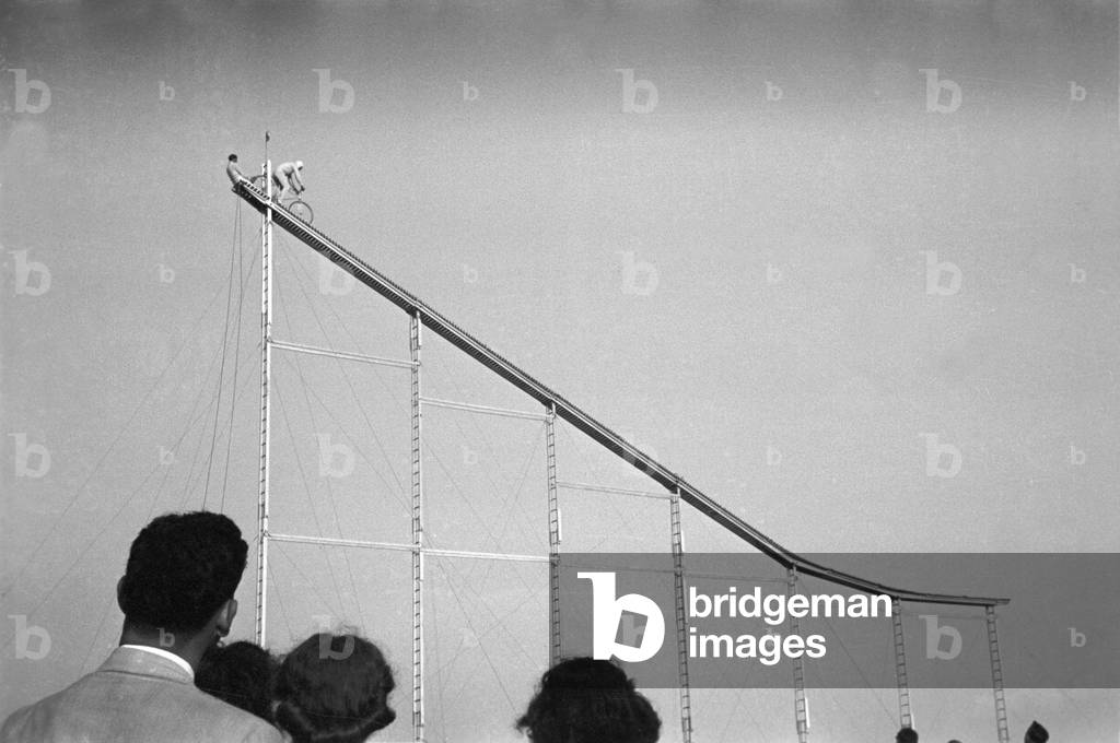 Daredevil preparing to dive into water from cycle down an elevated incline, by Lee Russell, state fair, Donaldsonville, Louisiana, November, 1938