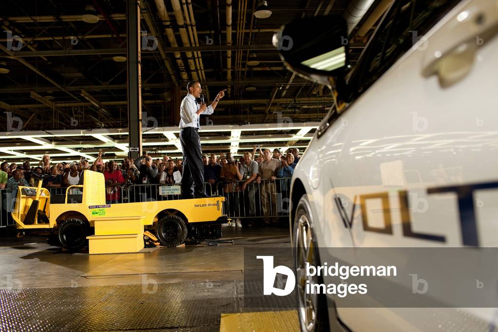 President Obama speaks to General Motors workers from the back of a utility vehicle. The Chevy Volt GM's plug-in hybrid electric vehicle is in the foreground. Hamtramck Michigan. July 30 2010. (BSWH_2011_8_159)