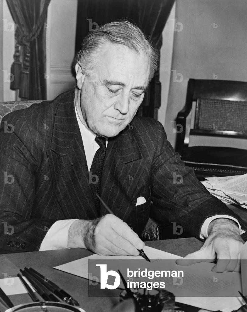 President Franklin D. Roosevelt signing the lend-lease bill to give aid to Great Britain, China and Greece. Roosevelt promised that the United States would not join the war, but instead, would become the 